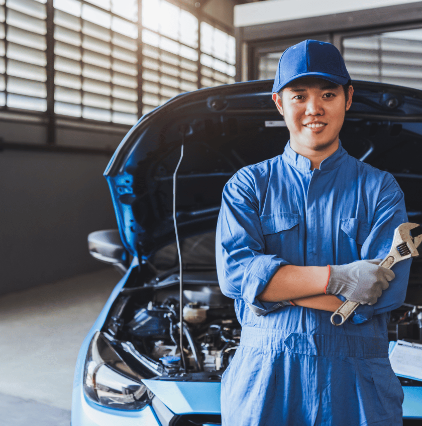 women leaning on the car front holding a shifting spanner