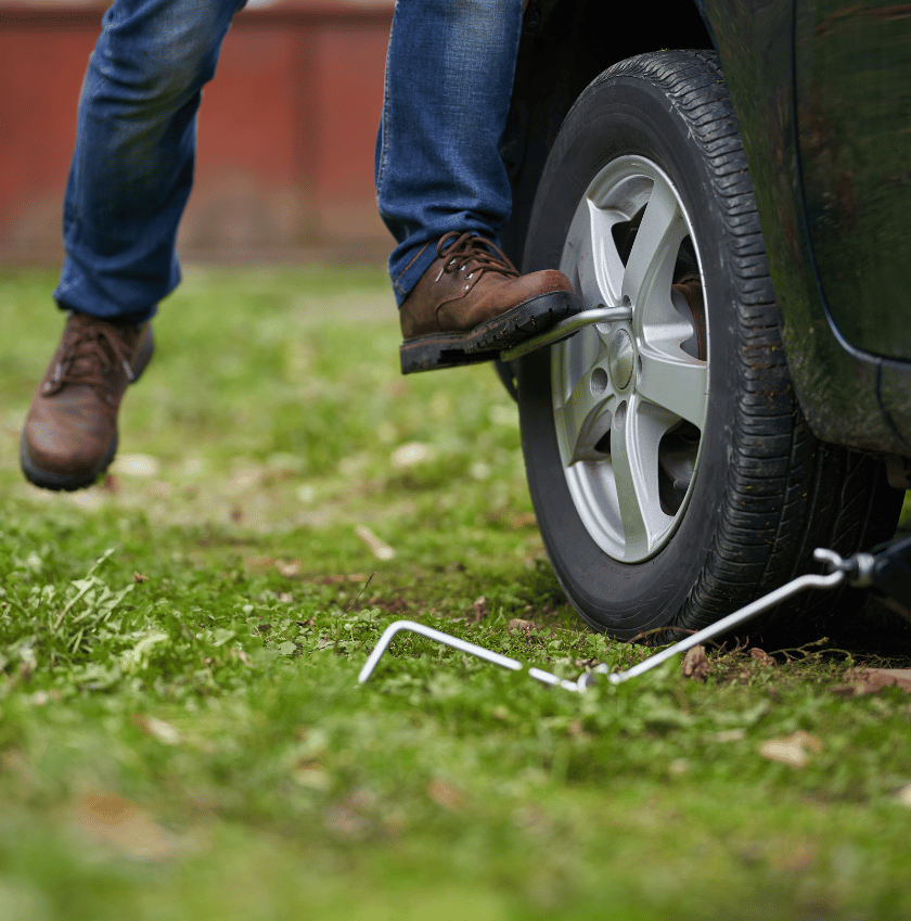 man removing nuts to change a car tyre